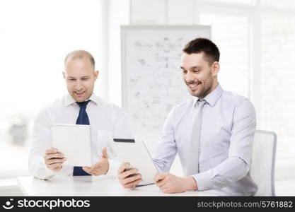 business, technology and office concept - two smiling businessmen with tablet pc computers in office