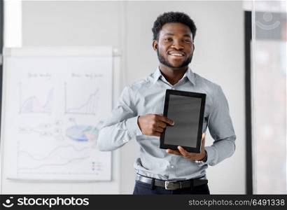 business, technology and people concept - african american businessman showing tablet pc computer at office presentation. businessman with tablet pc at office presentation. businessman with tablet pc at office presentation