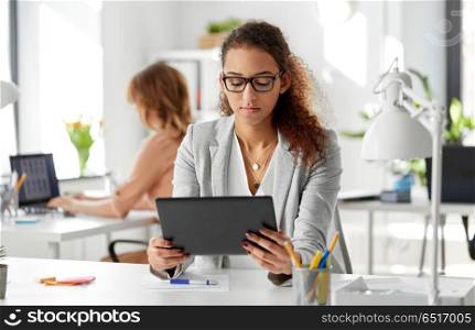 business, technology and people concept - african american businesswoman with tablet pc computer working at office. businesswoman with tablet pc working at office. businesswoman with tablet pc working at office