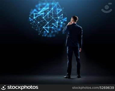 business, technology and people concept - businessman in suit looking at virtual network hologram over black background from back. businessman in suit from back over black