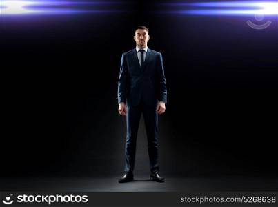 business, technology and people concept - businessman in suit over black background with laser light. businessman in suit over black with laser light