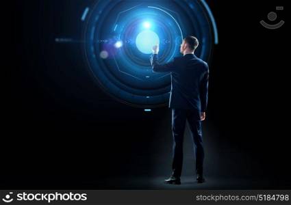 business, technology and people concept - businessman in suit touching virtual projection over black background. businessman in suit touching virtual projection