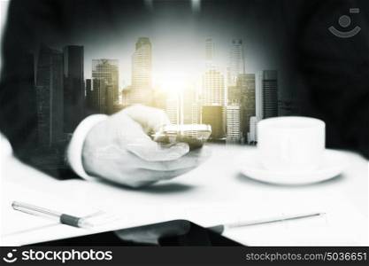 business, technology and people concept - businessman with smartphone and coffee at office over city buildings and double exposure effect. businessman with smartphone and coffee at office