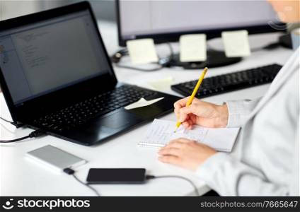 business, technology and people concept - businesswoman with notebook and laptop computer working at office. businesswoman with notebook and laptop at office
