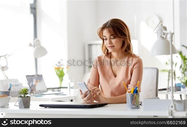 business, technology and people concept - businesswoman with smartphone working at office. businesswoman with smartphone working at office