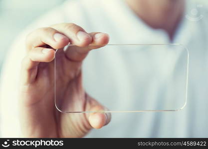 business, technology and people concept - close up of male hand holding and showing transparent smartphone at office