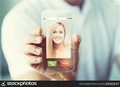 business, technology and people concept - close up of male hand holding and showing transparent smartphone with incoming call on screen