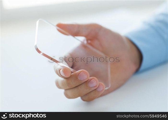 business, technology and people concept - close up of male hand holding and showing transparent smartphone at office