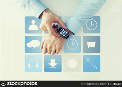 business, technology and people concept - close up of male hands setting smart watch with application icons on screen