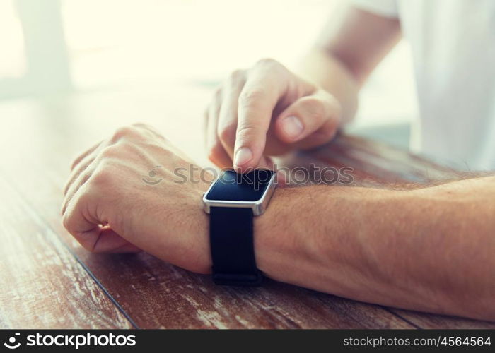 business, technology and people concept - close up of male hands setting smart watch at home. close up of male hands setting smart watch