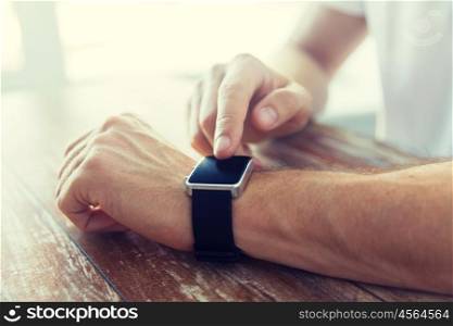 business, technology and people concept - close up of male hands setting smart watch at home. close up of male hands setting smart watch