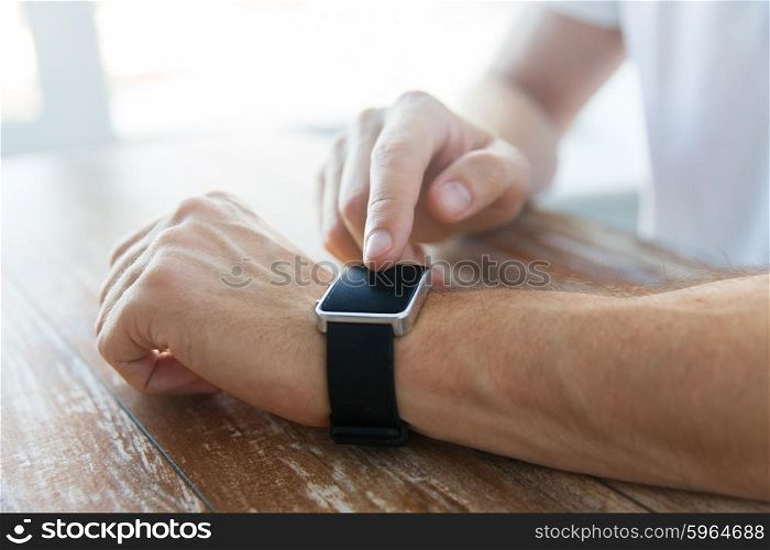 business, technology and people concept - close up of male hands setting smart watch at home