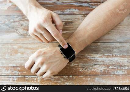 business, technology and people concept - close up of male hands setting smart watch at home