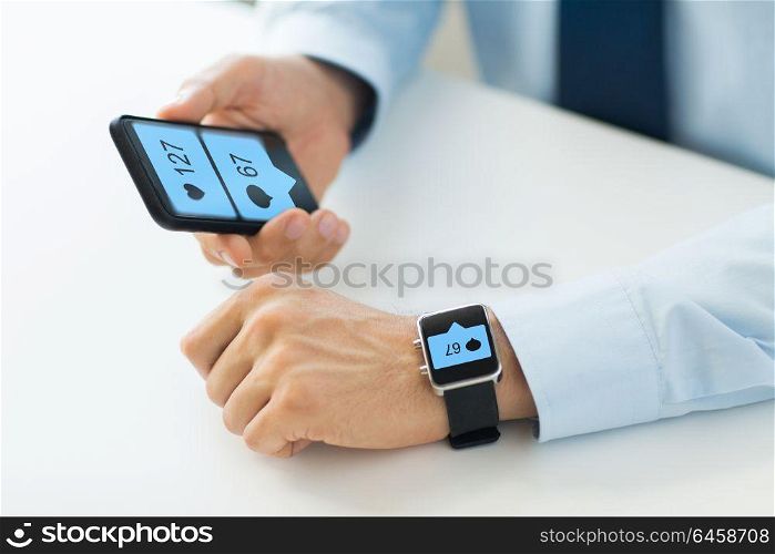 business, technology and people concept - close up of male hands with smartphone and smart watch with social media icons. hands with smartphone and smart watch social media