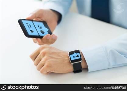 business, technology and people concept - close up of male hands with smartphone and smart watch with social media icons. hands with smartphone and smart watch social media