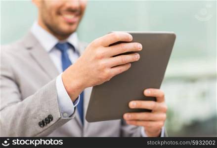 business, technology and people concept - close up of smiling man with tablet pc computer in city
