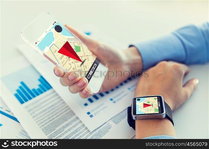 business, technology and people concept - close up of woman hand holding transparent smartphone and smart watch with navigator map on screen at office
