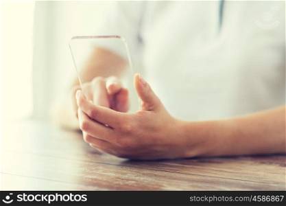 business, technology and people concept - close up of woman hand holding and showing transparent smartphone at home. close up of woman with transparent smartphone