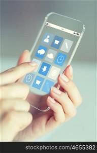 business, technology and people concept - close up of woman hand holding and showing transparent smartphone with application icons on screen