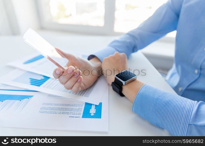 business, technology and people concept - close up of woman hand holding and showing transparent smart phone and watch at office