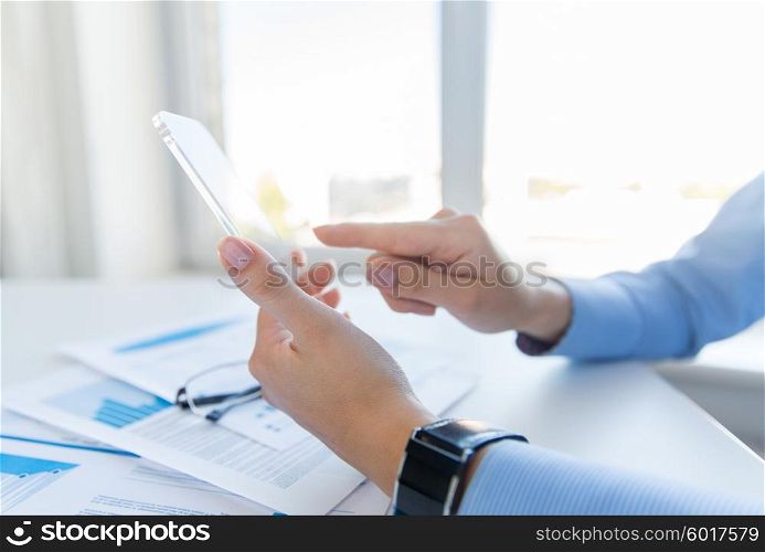 business, technology and people concept - close up of woman hand holding and showing transparent smartphone at office