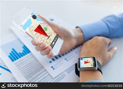 business, technology and people concept - close up of woman hand holding transparent smartphone and smart watch with navigator map on screen at office