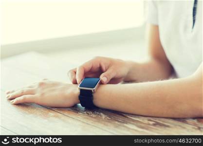 business, technology and people concept - close up of woman hands setting smart watch at home