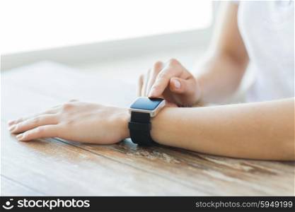 business, technology and people concept - close up of woman hands setting smart watch at home