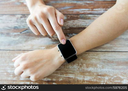 business, technology and people concept - close up of woman hands setting smart watch at home