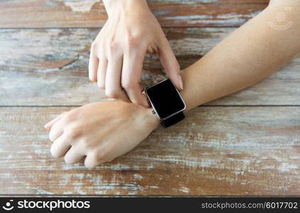 business, technology and people concept - close up of woman hands setting smart watch at home