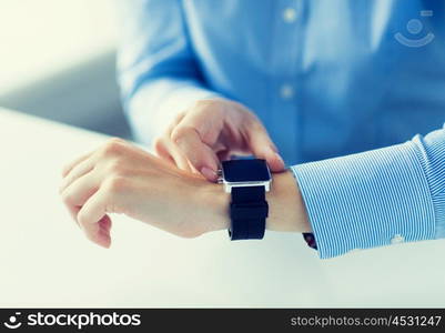 business, technology and people concept - close up of woman hands setting smart watch at office