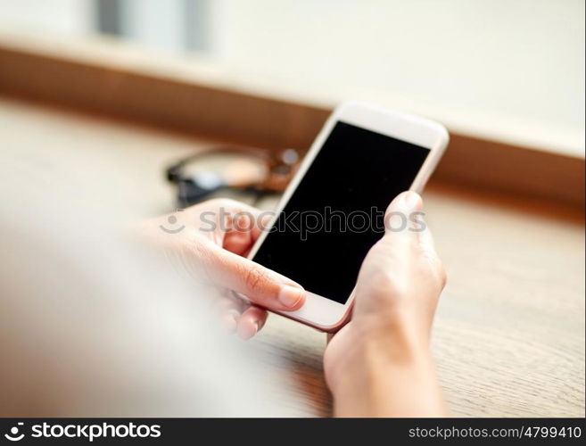 business, technology and people concept - close up of woman texting on smartphone