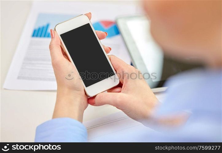 business, technology and people concept - close up of woman with smartphone at office. close up of woman with smartphone at office