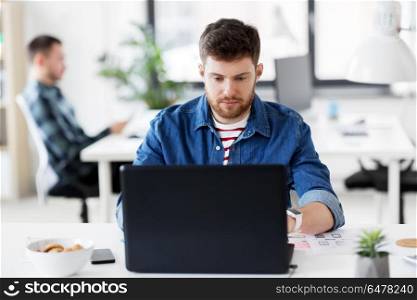 business, technology and people concept - creative man with laptop computer working at office. creative man with laptop working at office. creative man with laptop working at office