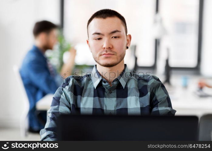 business, technology and people concept - creative man with laptop computer working at office. creative man with laptop working at office. creative man with laptop working at office