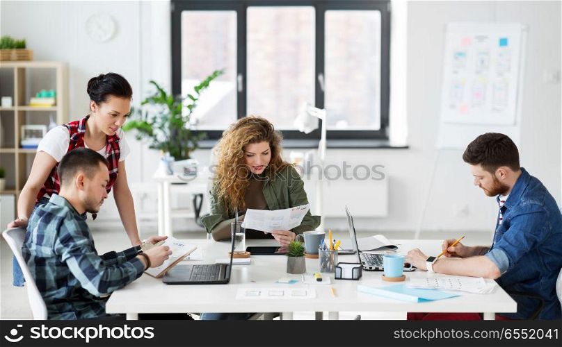 business, technology and people concept - creative team or designers working on user interface at office. creative team working on user interface at office. creative team working on user interface at office