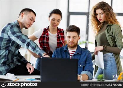 business, technology and people concept - creative team with laptop computer working at office. creative team with laptop working at office. creative team with laptop working at office