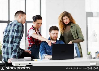 business, technology and people concept - creative team with laptop computer working at office. creative team with laptop working at office. creative team with laptop working at office