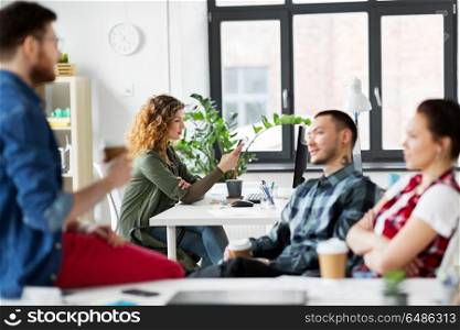 business, technology and people concept - creative woman with smartphone at office coffee break. creative woman with smartphone at office. creative woman with smartphone at office