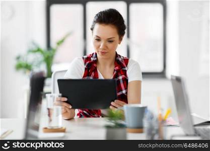 business, technology and people concept - creative woman with tablet pc computer working at office. creative woman with tablet pc working at office. creative woman with tablet pc working at office