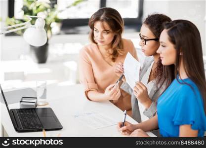 business, technology and people concept - female team or businesswomen with papers having video conference by laptop computer at office. businesswomen having video conference at office. businesswomen having video conference at office