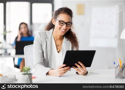 business, technology and people concept - happy smiling african american businesswoman with tablet pc computer working at office. businesswoman with tablet pc working at office. businesswoman with tablet pc working at office