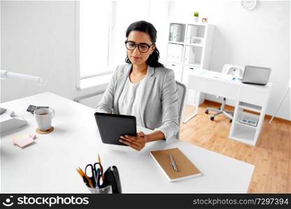 business, technology and people concept - indian businesswoman with tablet pc computer working at office. businesswoman with tablet computer at office