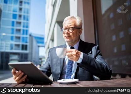 business, technology and people concept - senior businessman with tablet pc computer drinking coffee at city street cafe