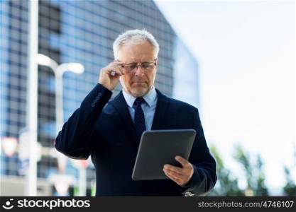 business, technology and people concept - senior businessman with tablet pc computer on city street