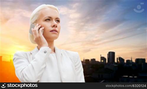 business, technology and people concept - serious businesswoman with smartphone talking over city background. serious businesswoman with smartphone outdoors