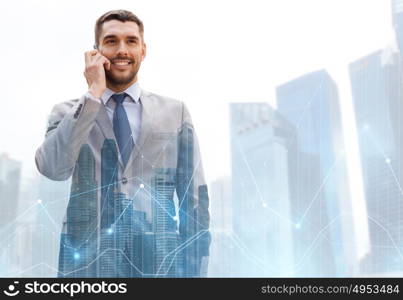 business, technology and people concept - smiling businessman calling on smartphone over city and office buildings with charts background. happy businessman calling on smartphone in city