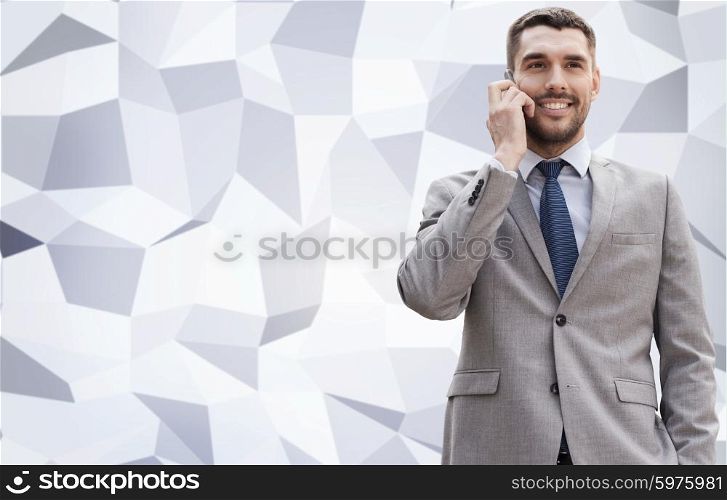 business, technology and people concept - smiling businessman with smartphone talking over office building over gray graphic low poly background