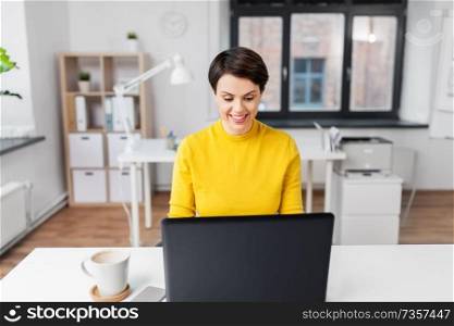business, technology and people concept - smiling businesswoman with laptop computer working at office. happy businesswoman with laptop working at office