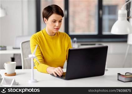 business, technology and people concept - smiling businesswoman with laptop computer working at office. happy businesswoman with laptop working at office